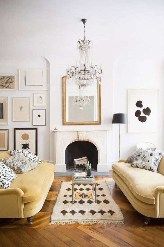 bright modern glam parisian interior design with yellow velvet couches and gilded mirror