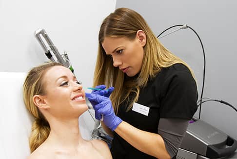 Female nurse performing a botox injection on the side of the face