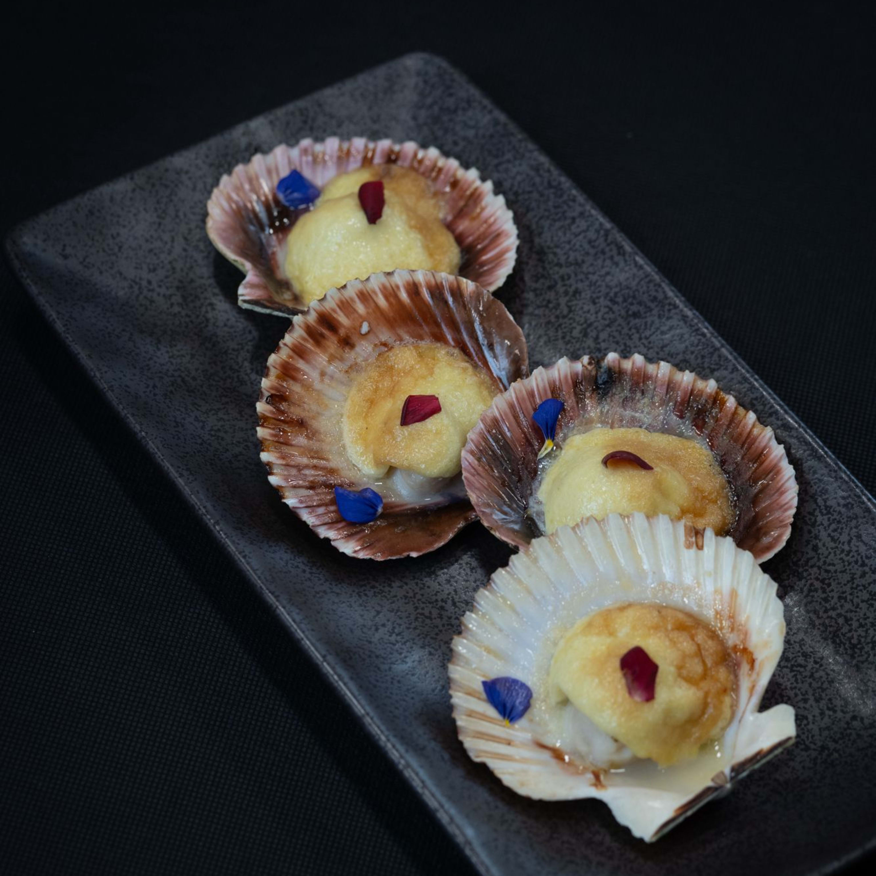 Langostinos al ajillo al txakolin con chips de ajo y cebollino fresco