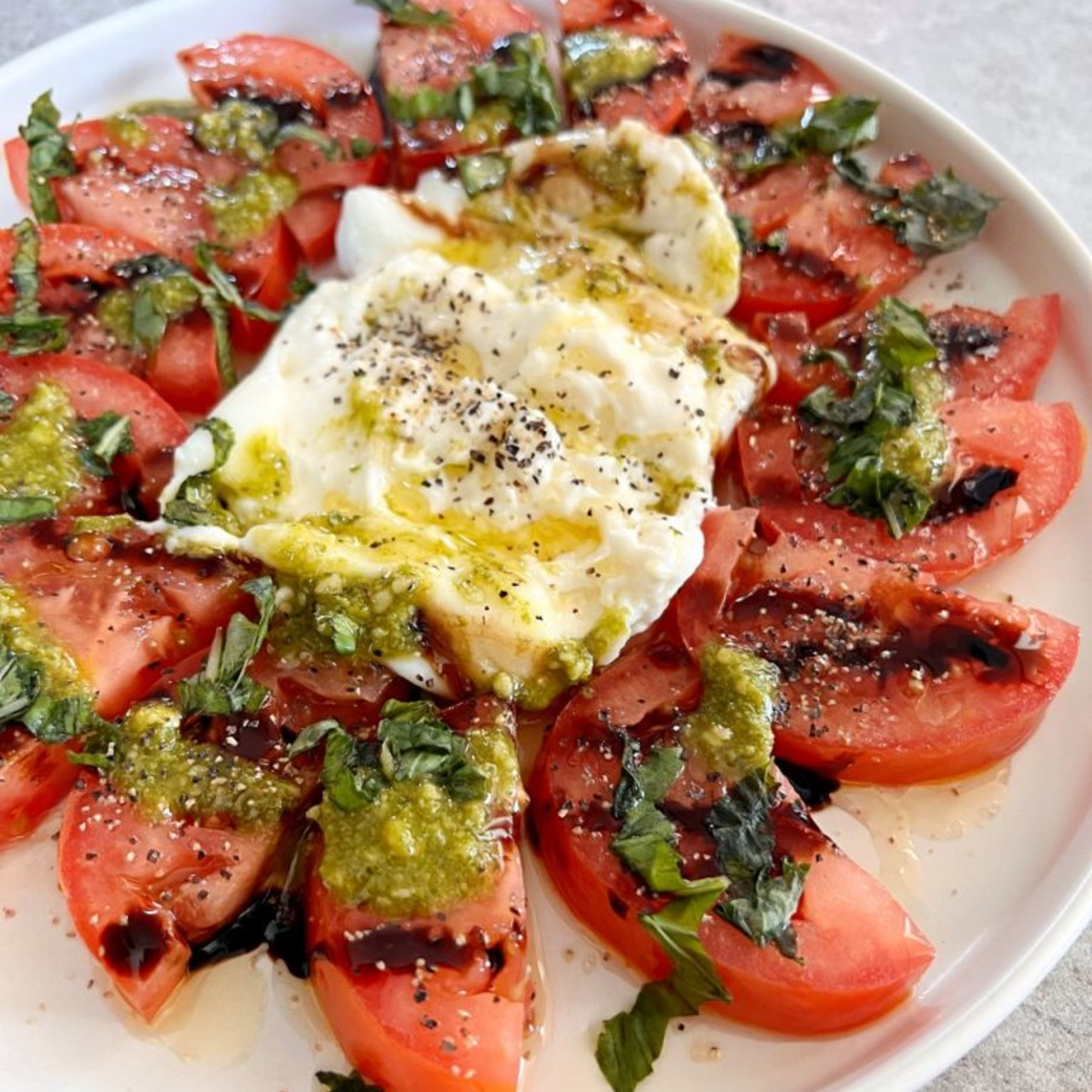 Ensalada de tomate rosa con burrata, albahaca y pesto