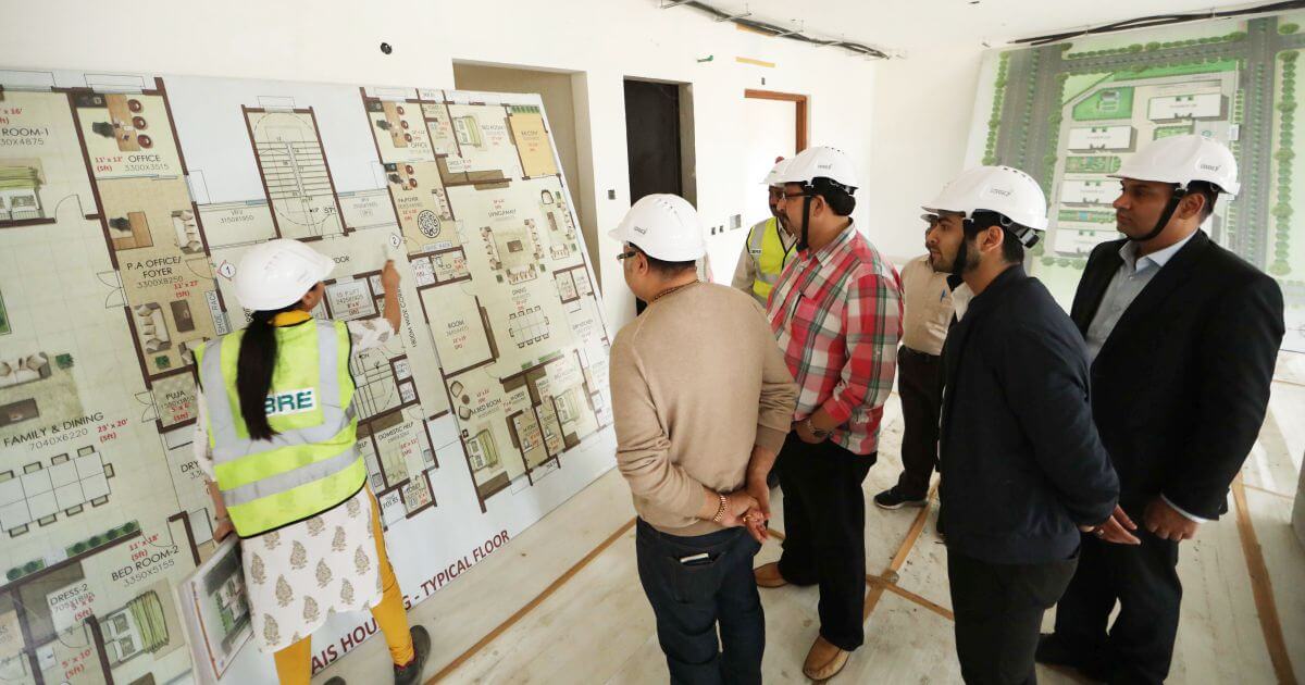 Shri Vikas Sharma and members of the delegation learning about the floor plans of government accommodation