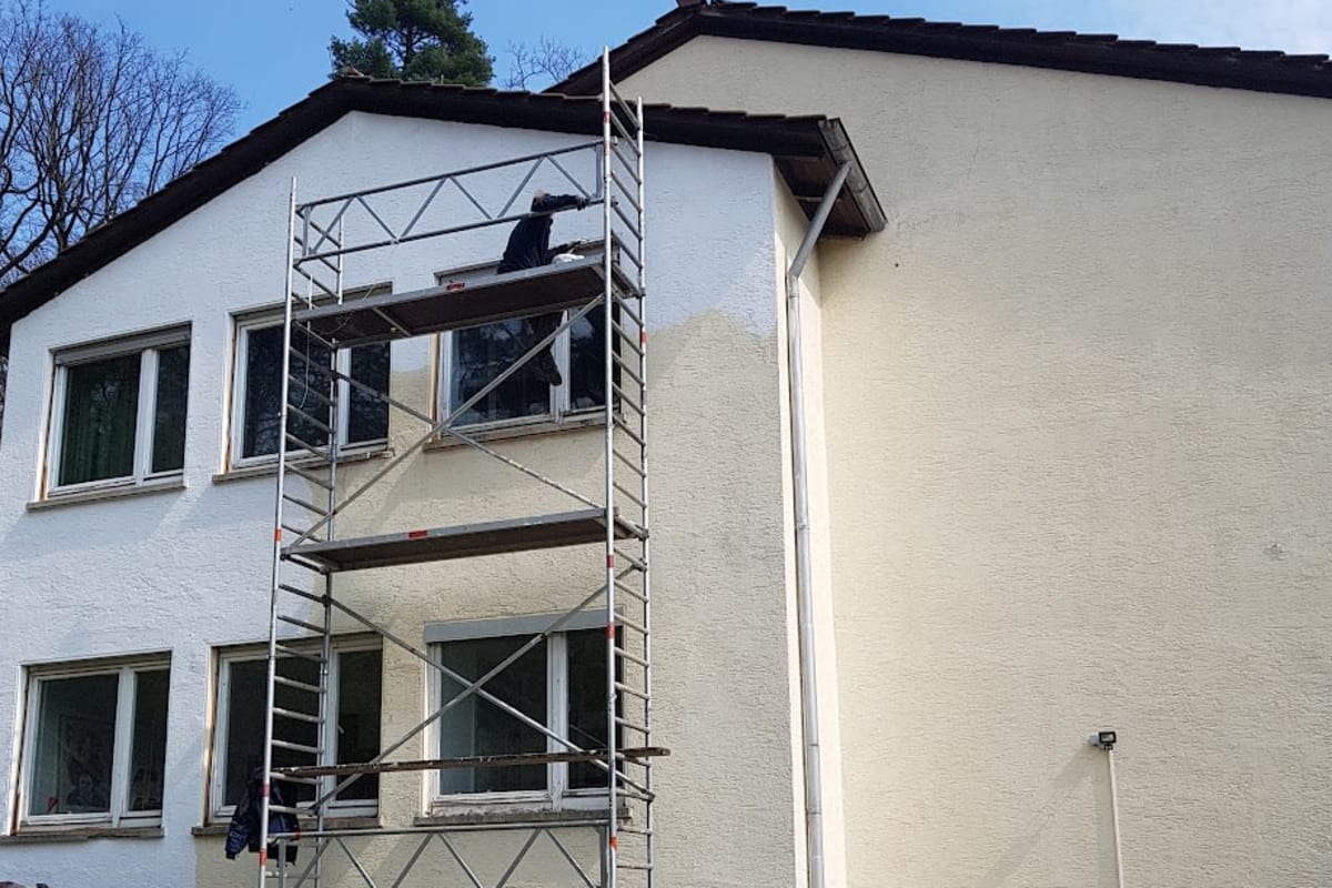 Gerüst am Wohnhaus, Fensterrahmen werden gestrichen