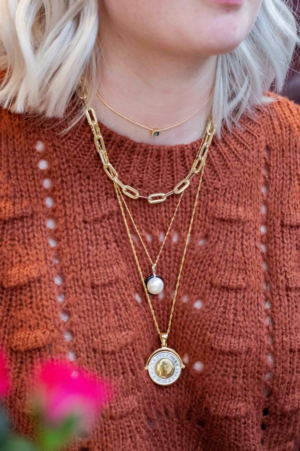 Model wearing gold necklace and two pendants. Products 926742, 929177, 913578 and 900733.