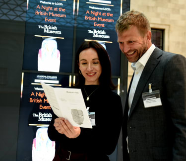 Two people looking at a magazine in the British Museum