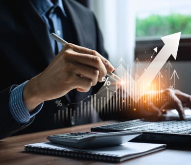 A man working at a desk with an upward arrow symbolizing growth