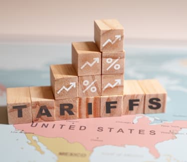Wooden blocks spelling out 'tariffs', symbolizing the impact of economic policies on trade