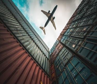 Plane flying top of containers