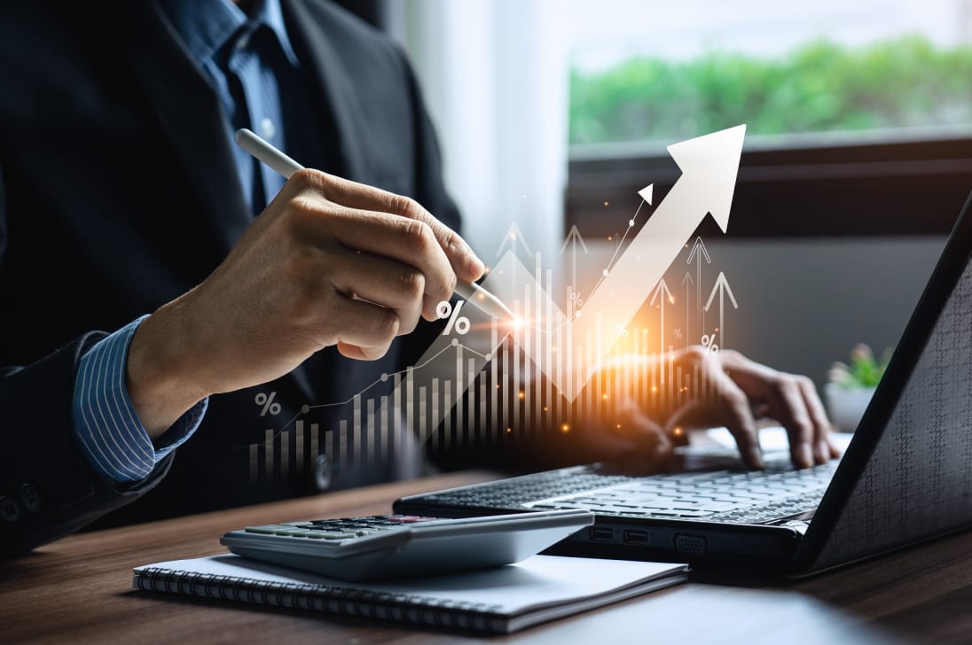 A man working at a desk with an upward arrow symbolizing growth