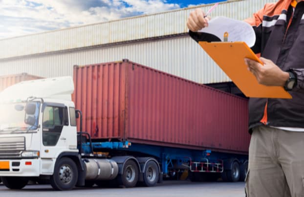 Man working with a truck checking documents