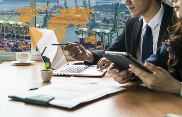 Business professionals in a meeting looking a laptop