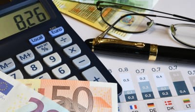 Image of pound notes, a calculator, glasses and a pen
