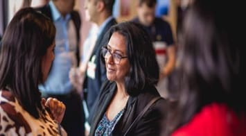 two woman talking at t networking event