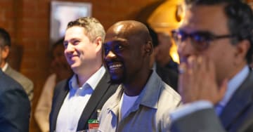 Young black man smiling at a networking event