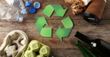 Recycling symbol with waste around