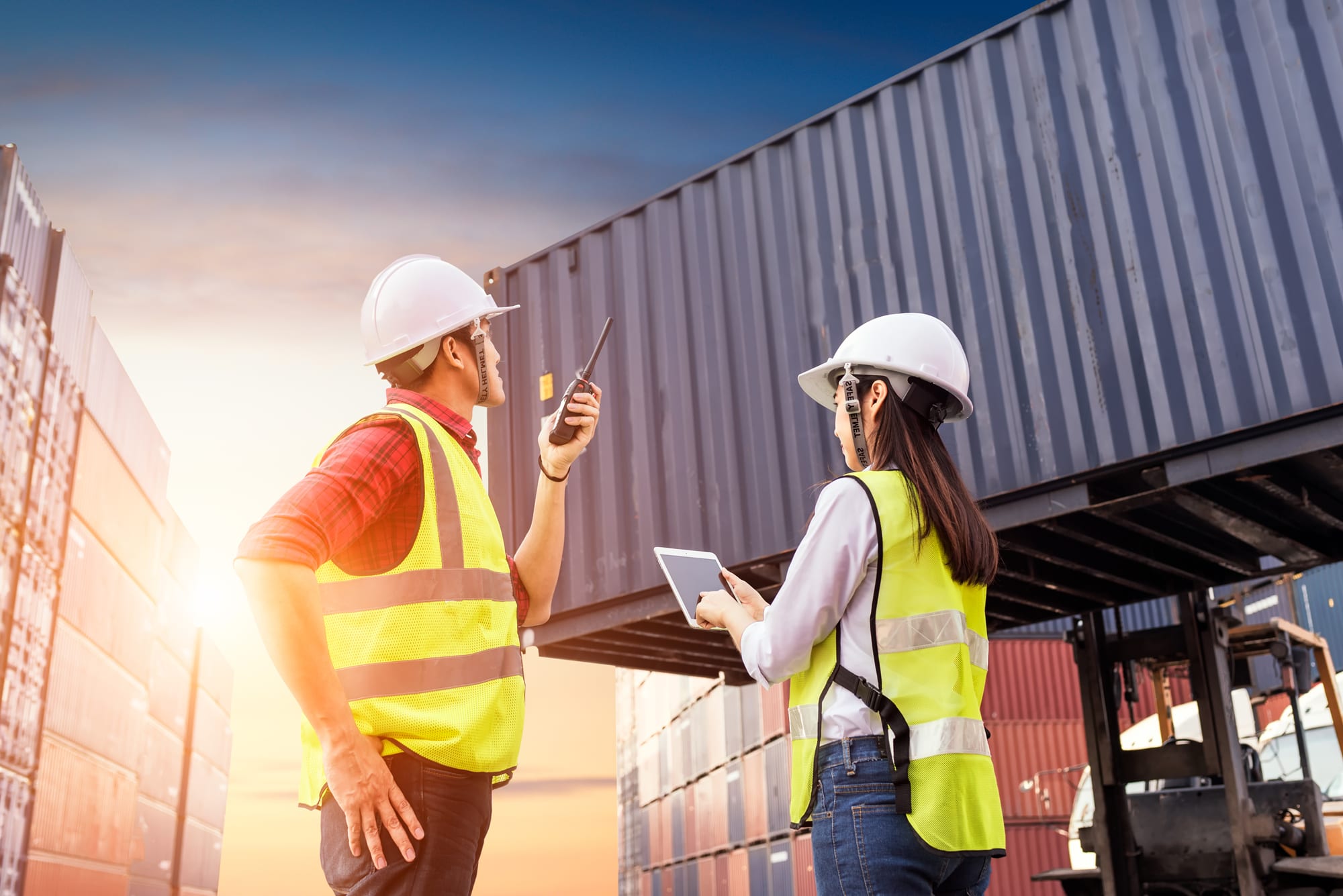 Two people in a port watching a container
