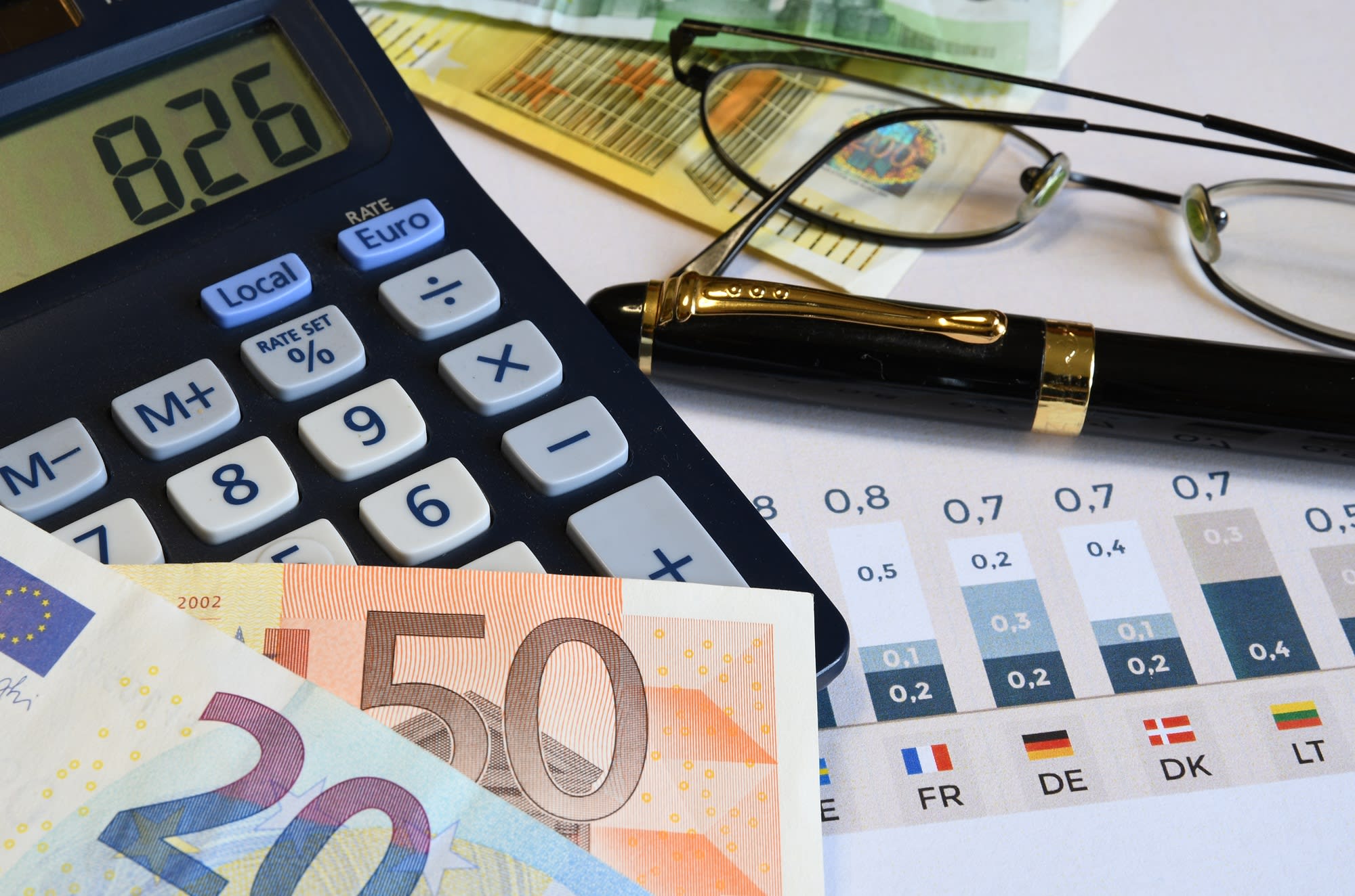 Image of pound notes, a calculator, glasses and a pen