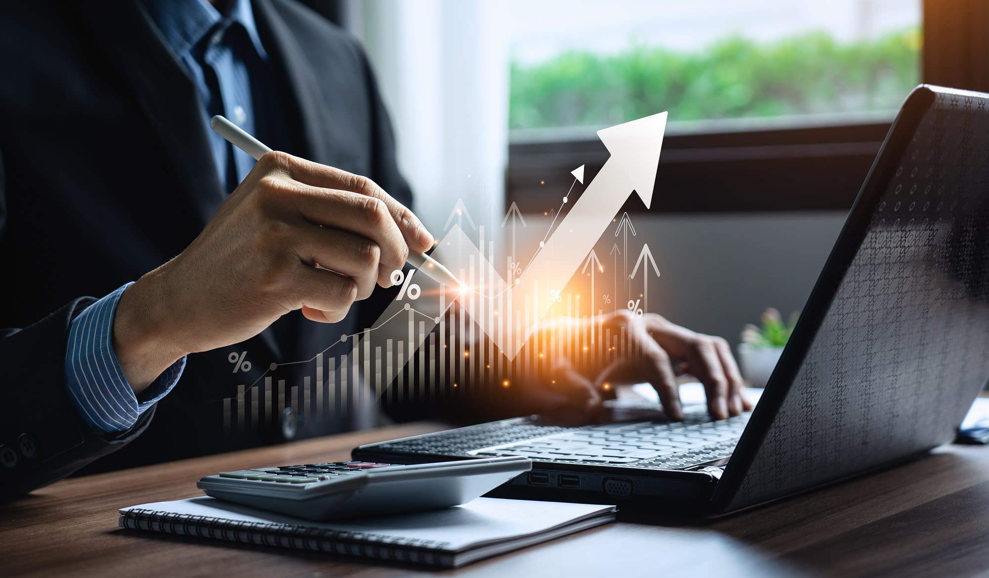 A man working at a desk with an upward arrow symbolizing growth