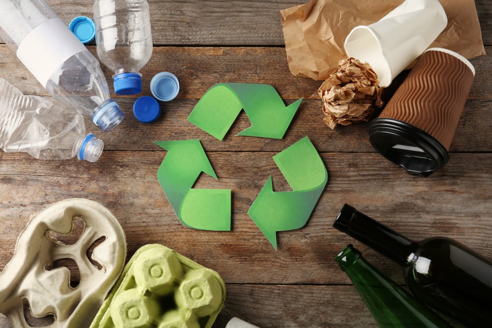 Recycling symbol with waste around