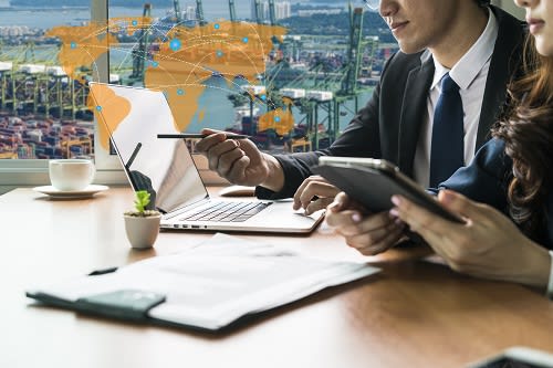Business professionals in a meeting looking a laptop