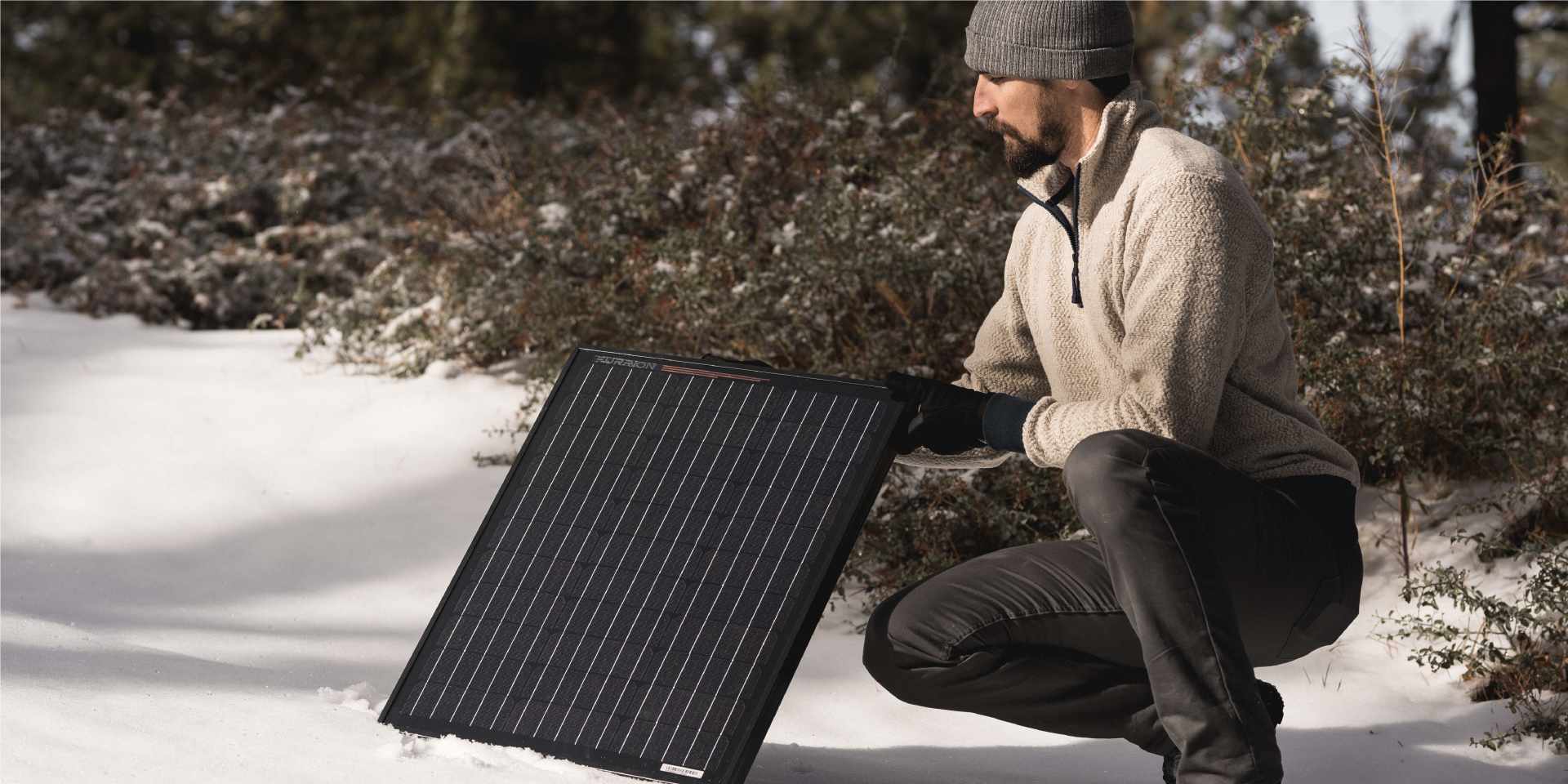 Person setting up a Furrion solar panel in the snow