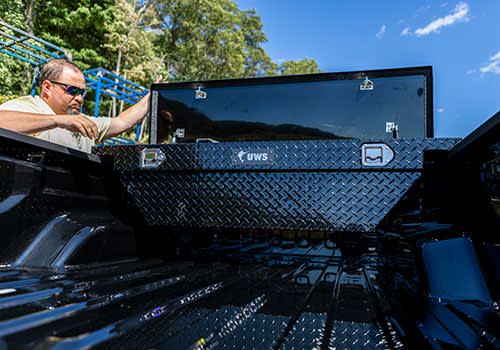 Man Reaching in Black Truck Tool Box