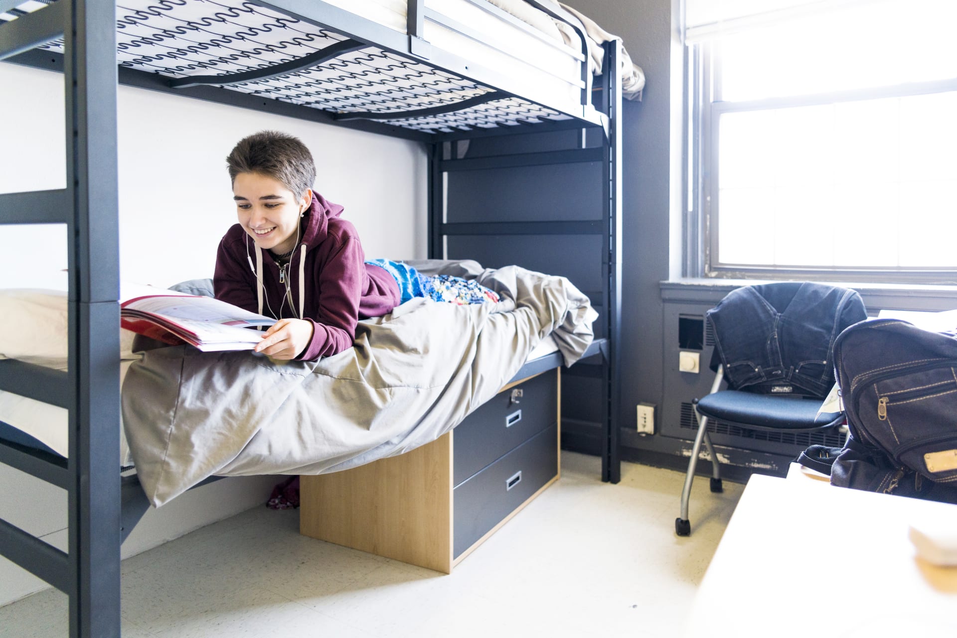 College Student on Dorm Mattress Studying