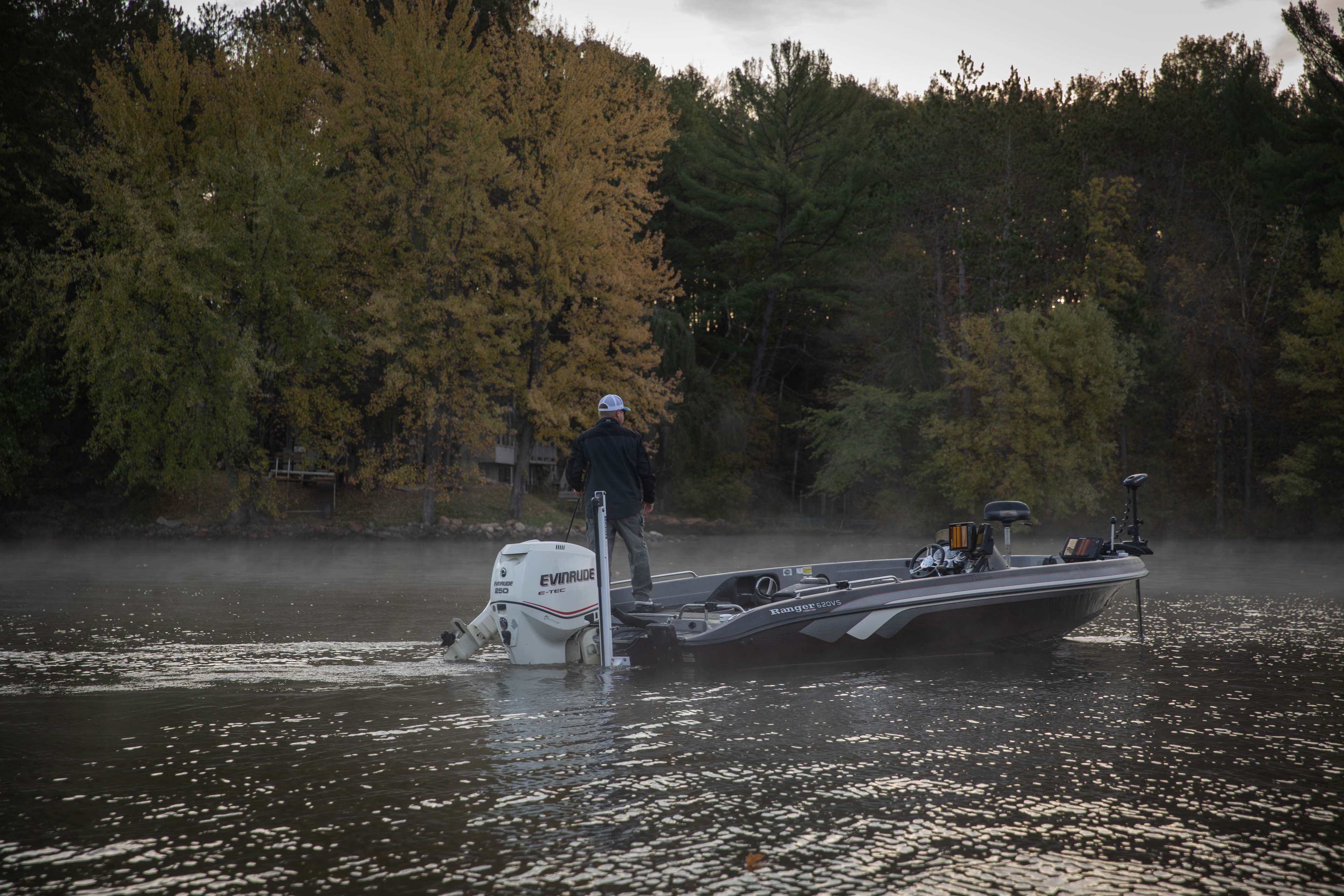 Weekend boater and family anchored in a calm freshwater cove at golden hour with Lewmar Vector manual shallow water anchor, fishing rods out