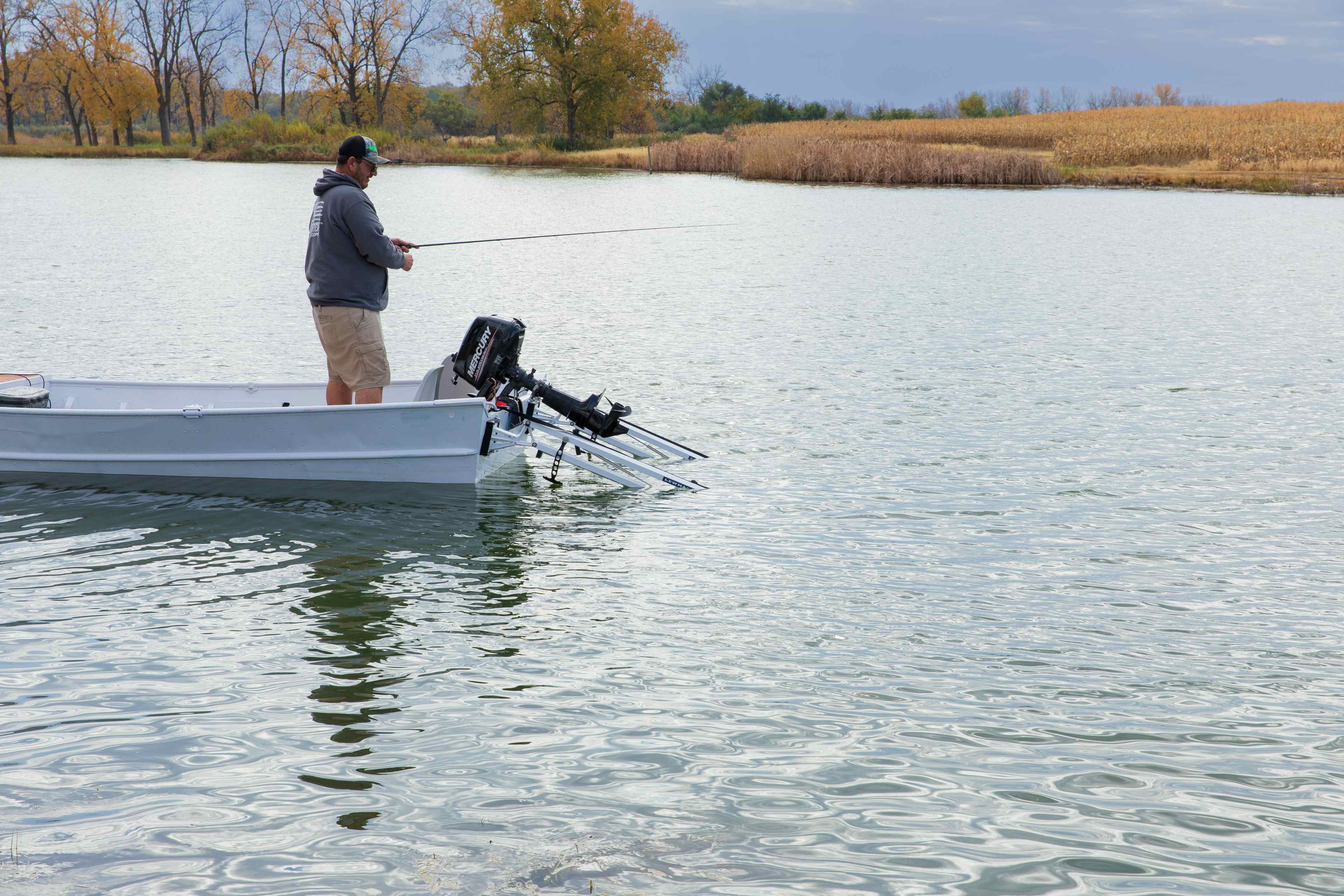 Angler casting from the bow of a jon boat while a shallow water anchor holds the stern