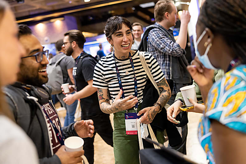 LeadDev London delegates talking animatedly in the sponsor hall in 2022