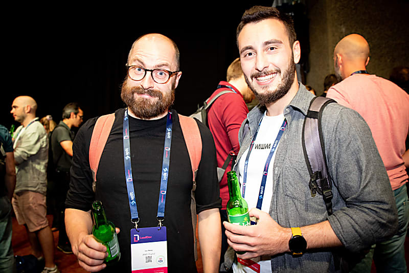 Two LeadDev delegates photographed while enjoying a beer together, smiling at the camera