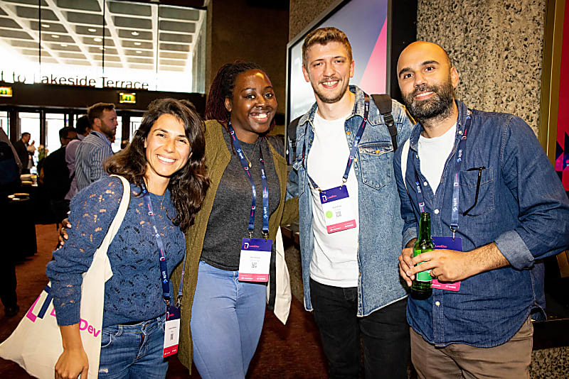 A group of 4 delegates at LeadDev London, smiling for the camera while enjoying a drink