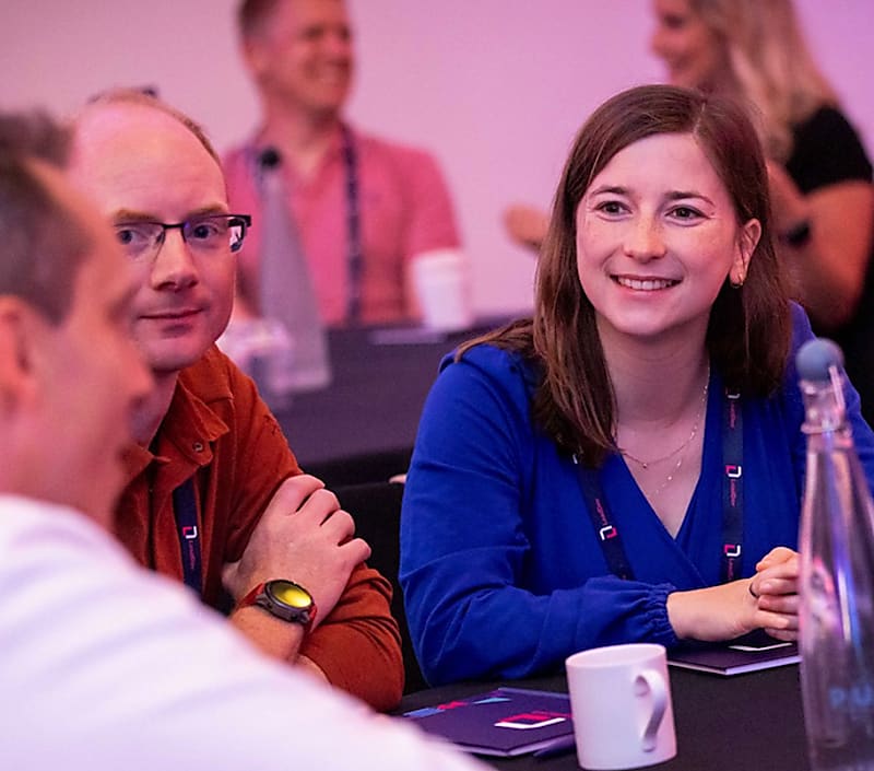Audience members at LeadingEng London 2022 smiling and holding a conversation