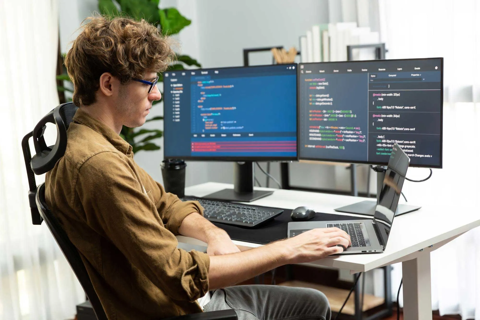 Developer working remotely with multiple coding screens