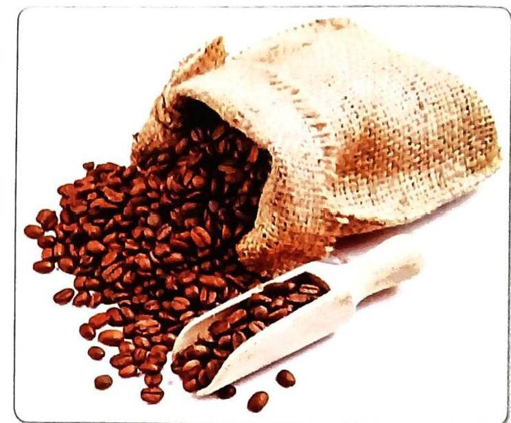 A burlap sack overflows with roasted coffee beans, with some spilled onto a white surface alongside a wooden scoop filled with more beans.