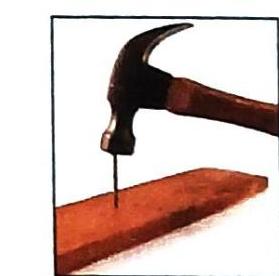 A hammer strikes a nail embedded in wood.