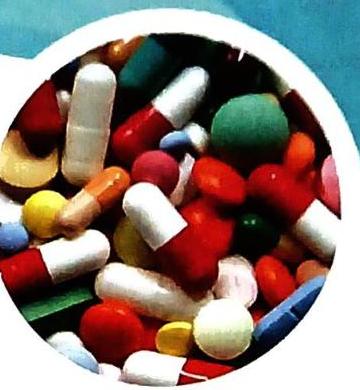 A close-up of numerous colorful pharmaceutical capsules and pills, including red, white, orange, yellow, green, and blue, jumbled together.