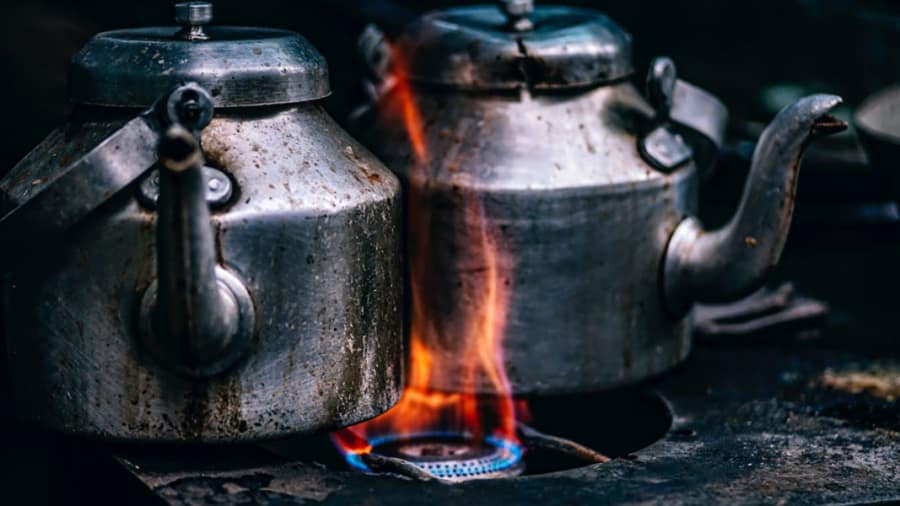Two old kettles boiling on the stove