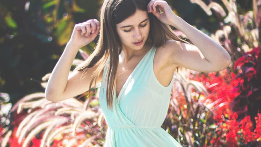 Girl with blue dress outside looking at armpits for hidradenitis suppurativa