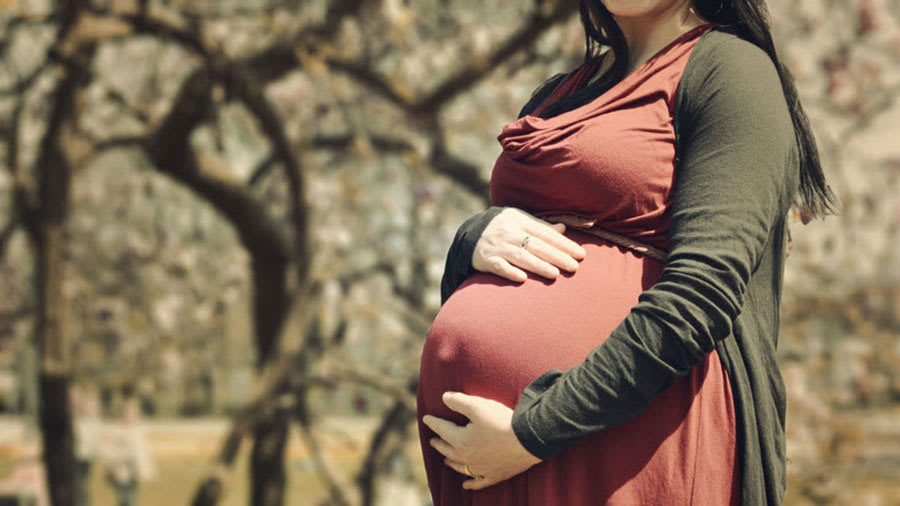 pregnant-woman-in-red-dress-holding-belly