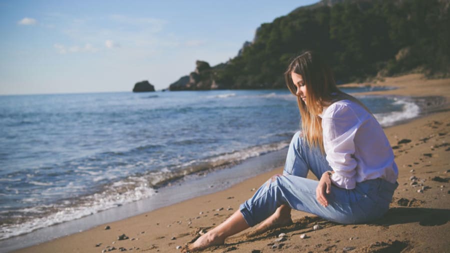 woman with hpv warts witting on beach