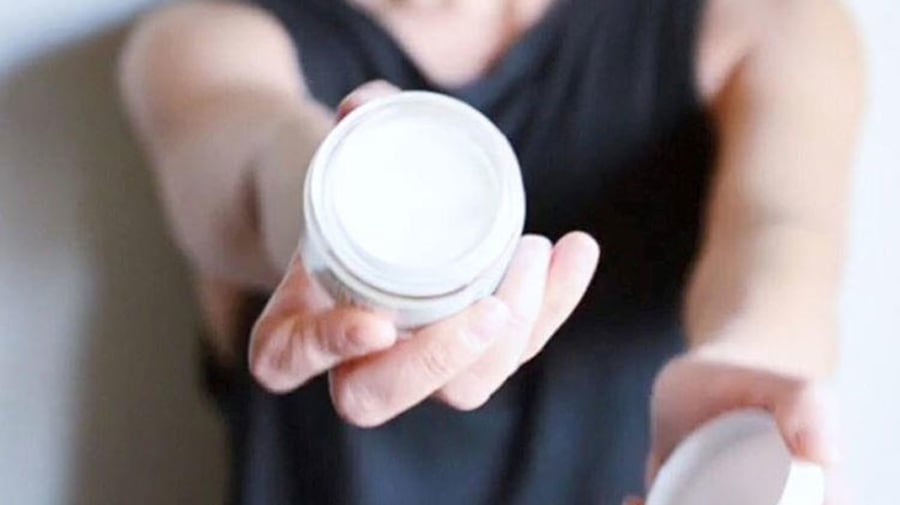 woman holding fragrance free product in jar