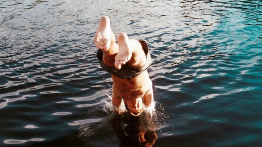 Man with eczema diving into water for hydrotherapy