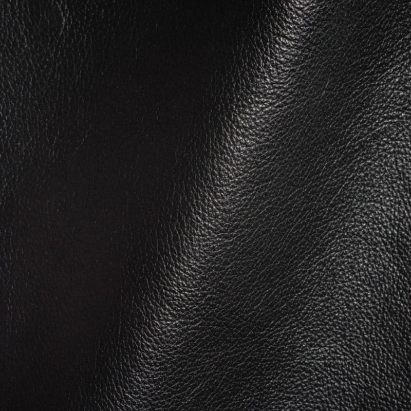 Antique leather sauvage two-tone finish Close-up of black antique leather showing the two-tone sauvage finish, with lighter and darker hues blending across the natural fine grain