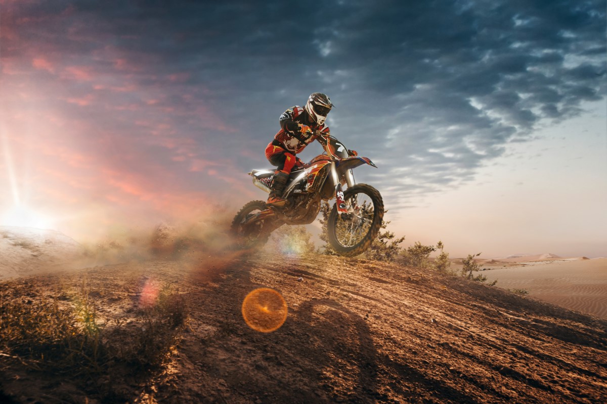 A person riding a motocross bike in the desert.