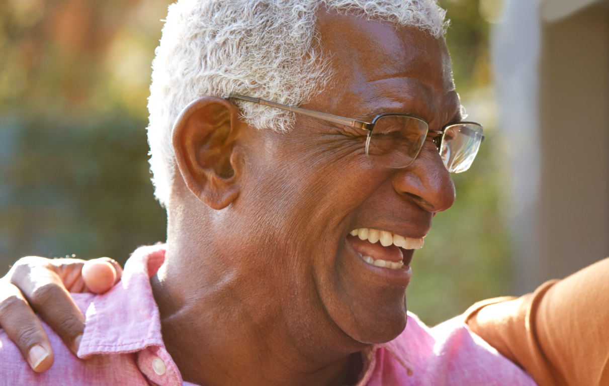 Grey-haired man laughing.