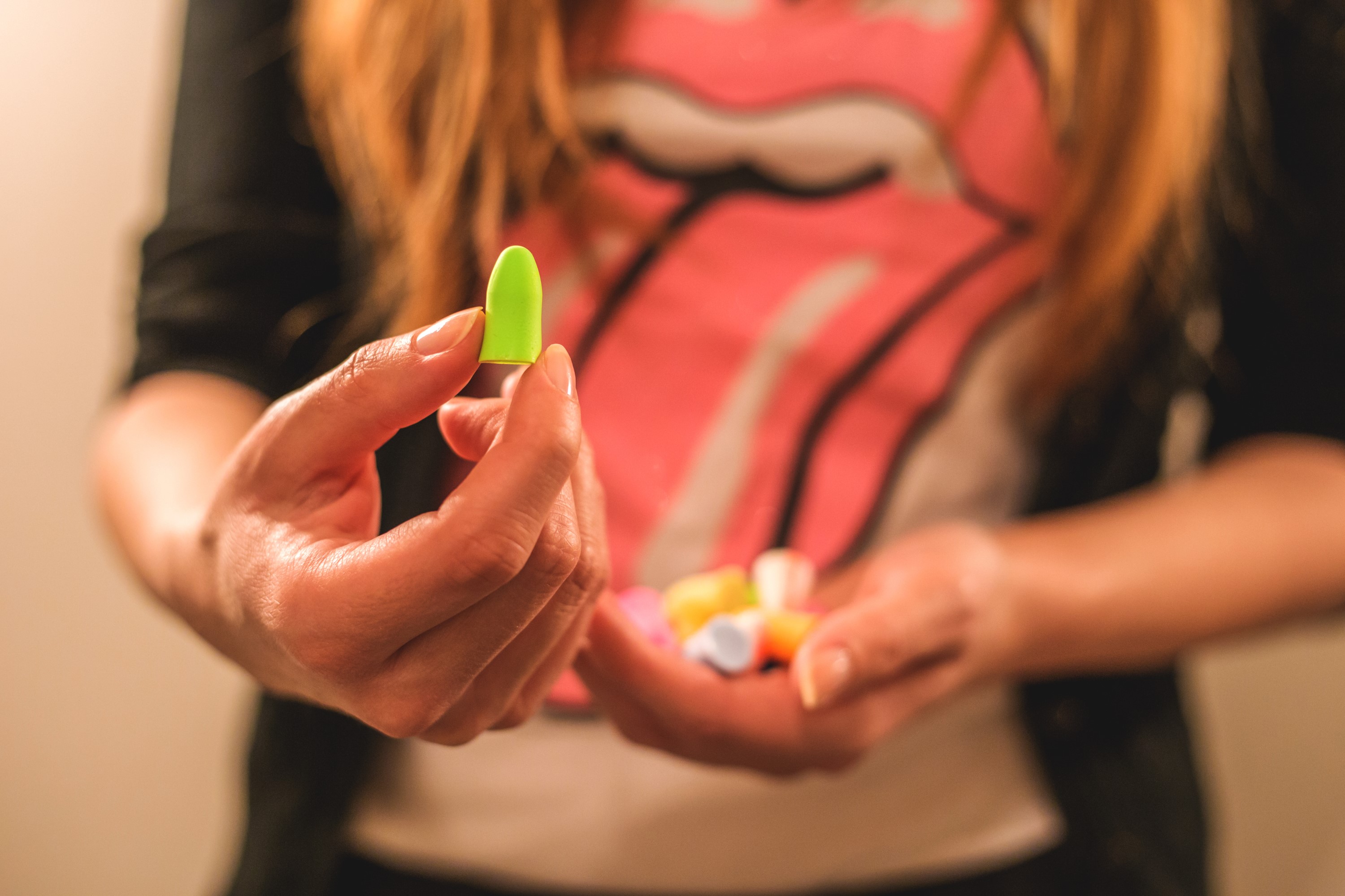 girl wearing band tshirt holding earplugs