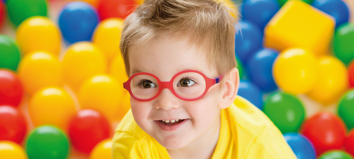 A child wearing Nano Vista glasses while playing in a colourful ball bath.