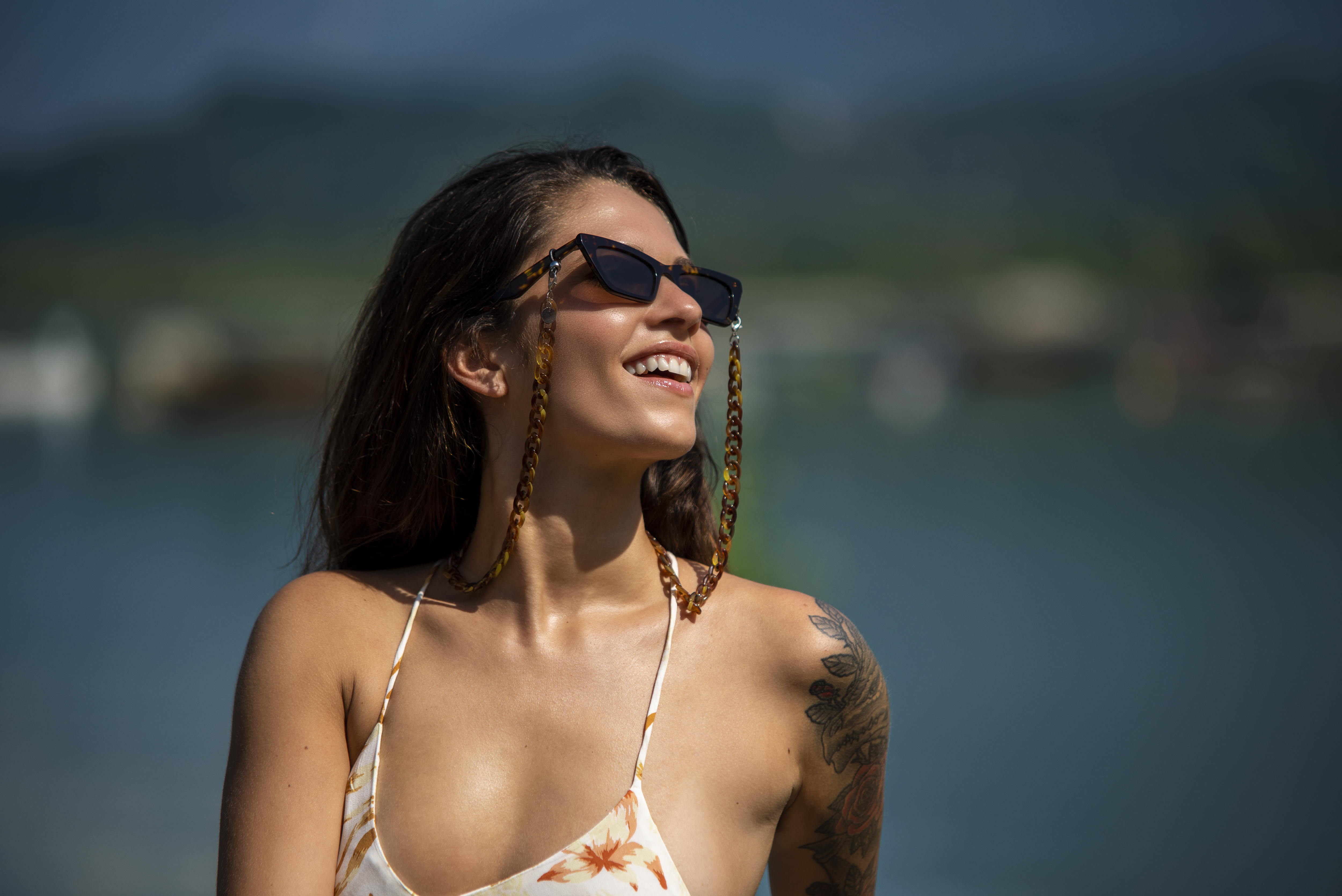 A woman wearing Sunglasses with Joen Mini pop chains and swimming costume.