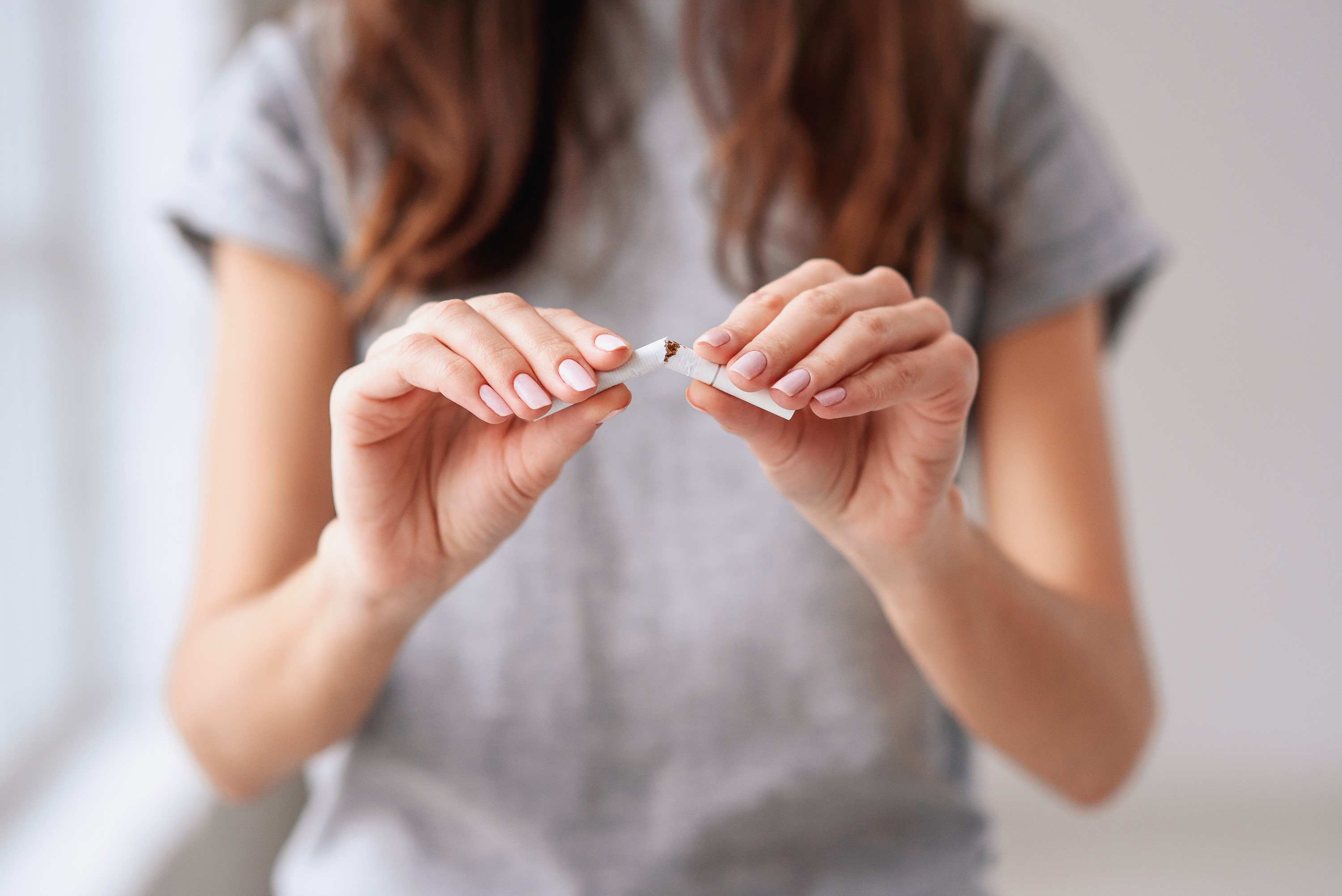 A woman breaking a cigarette.