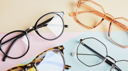 Multiple eyeglasses on a multicolored background of pastel colours.